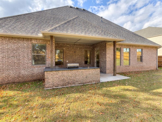 back of property featuring a lawn and a patio