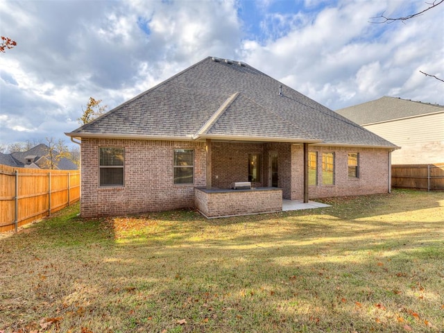 back of property featuring area for grilling, a patio area, and a yard