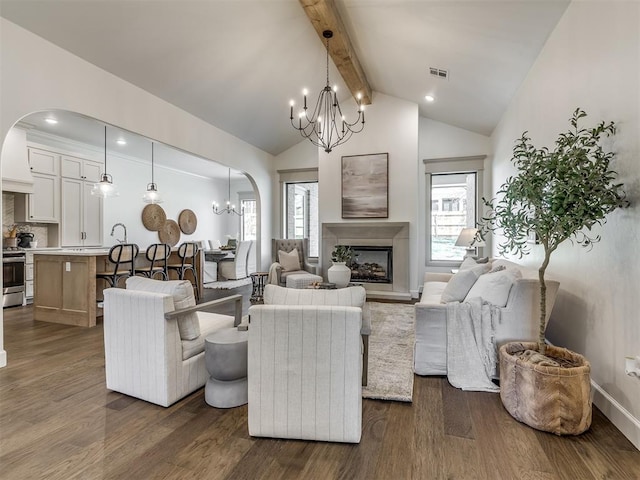 living room with a notable chandelier, plenty of natural light, lofted ceiling with beams, and dark wood-type flooring