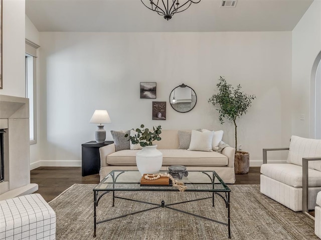 living room featuring dark hardwood / wood-style flooring and an inviting chandelier