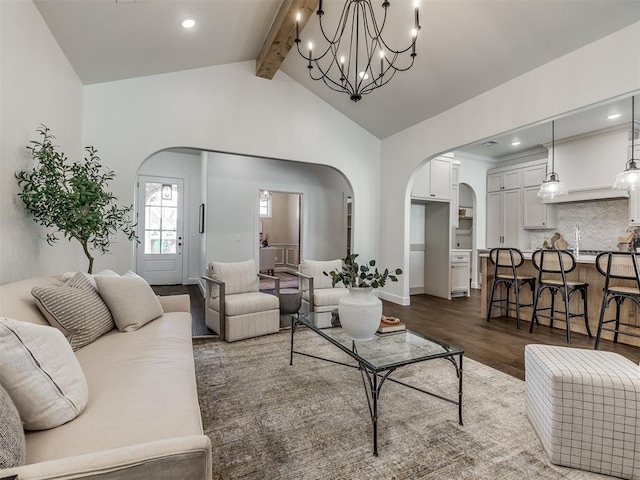 living room featuring beam ceiling, dark hardwood / wood-style flooring, high vaulted ceiling, and a notable chandelier