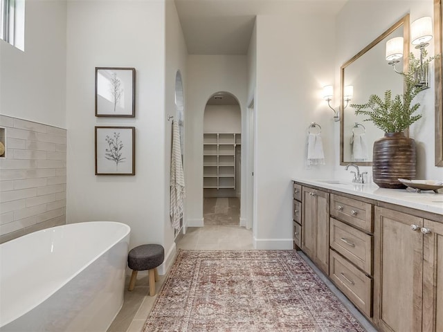 bathroom with tile patterned floors, a bathtub, and vanity