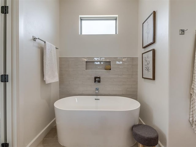 bathroom with tile patterned flooring and a tub to relax in