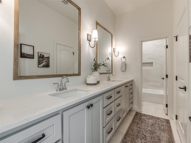 bathroom featuring tile patterned flooring, vanity, and tiled shower / bath