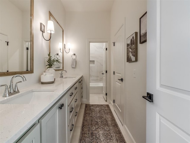 bathroom with tile patterned flooring, vanity, and tiled shower / bath