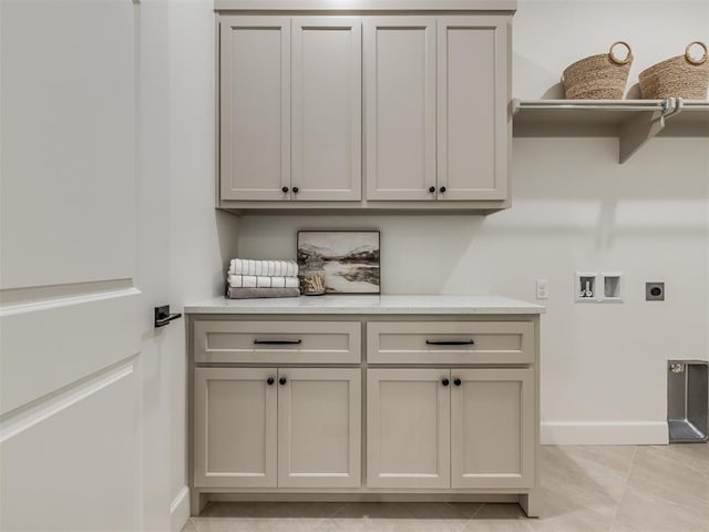 laundry area featuring hookup for an electric dryer, light tile patterned flooring, cabinets, and hookup for a washing machine