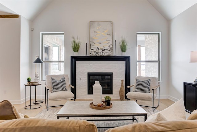 living room featuring high vaulted ceiling and light hardwood / wood-style floors