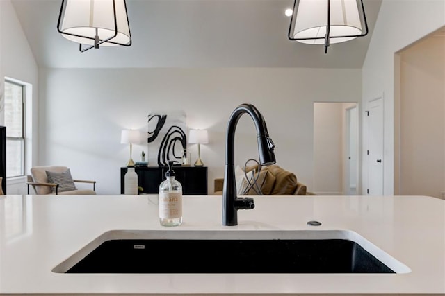 kitchen featuring lofted ceiling, sink, and hanging light fixtures