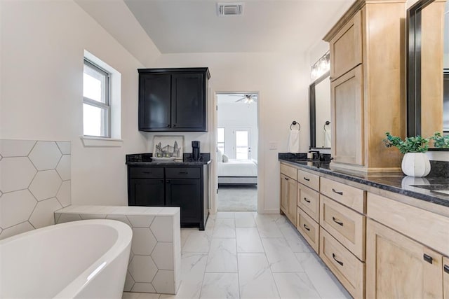 bathroom with vanity, ceiling fan, and a bath