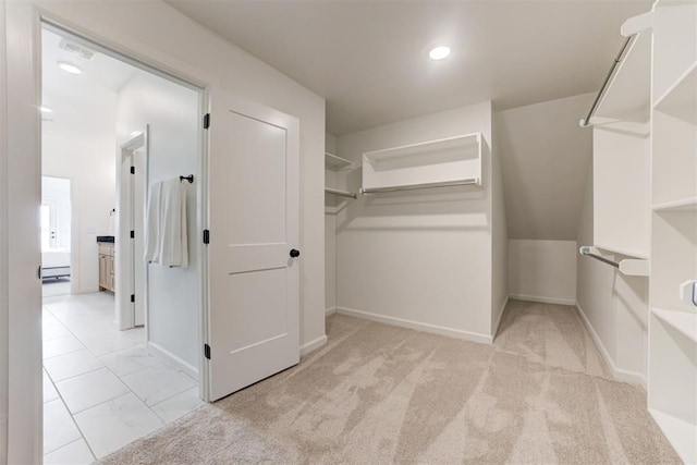 spacious closet featuring light colored carpet