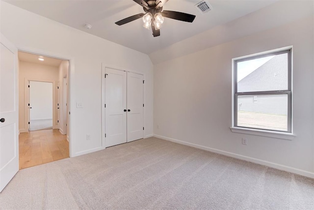 unfurnished bedroom featuring light colored carpet and ceiling fan