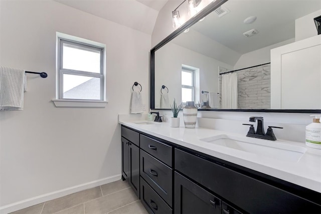 bathroom with tile patterned flooring, vanity, walk in shower, and vaulted ceiling