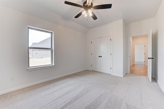 unfurnished bedroom with ceiling fan, a closet, and light colored carpet