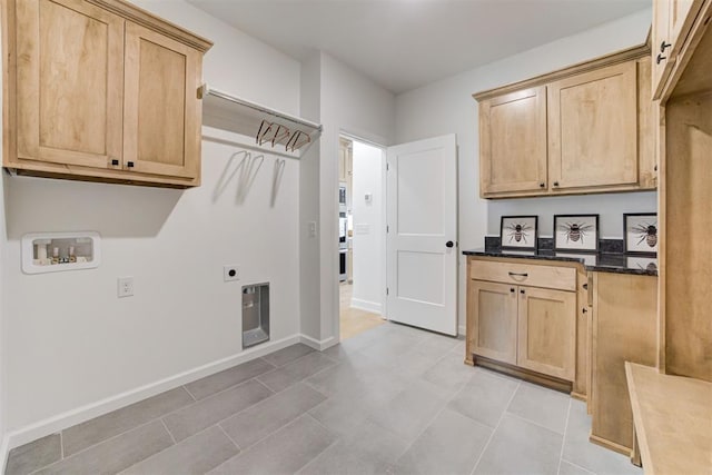 kitchen with light brown cabinets, light tile patterned flooring, and dark stone counters