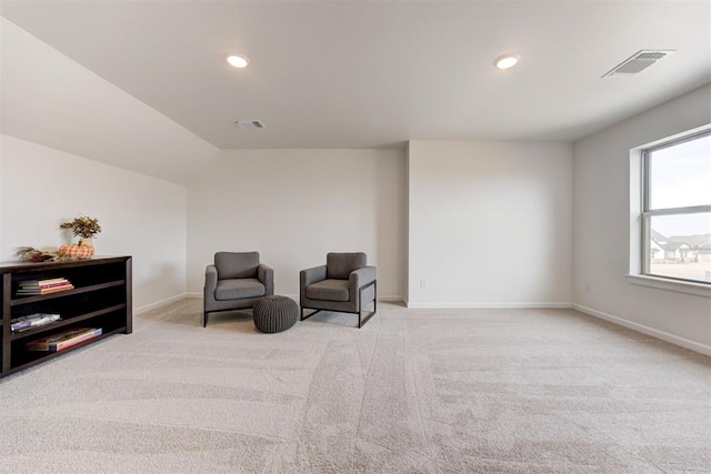 sitting room featuring light carpet and vaulted ceiling