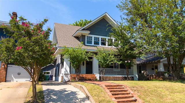 view of front of house with a front lawn, a porch, and a garage