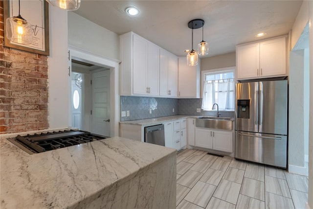 kitchen featuring light stone counters, sink, white cabinets, and appliances with stainless steel finishes