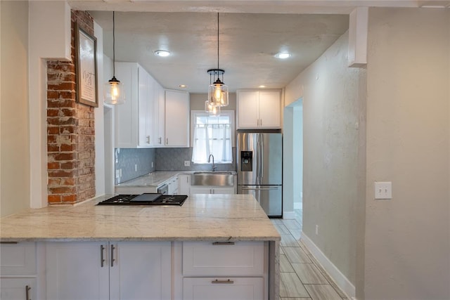 kitchen featuring white cabinets, pendant lighting, light stone countertops, and appliances with stainless steel finishes