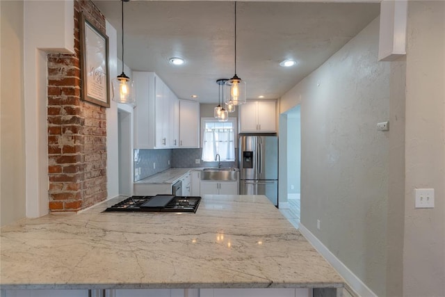 kitchen featuring kitchen peninsula, stainless steel appliances, and white cabinetry