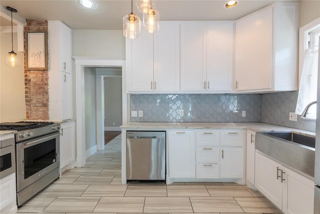 kitchen with white cabinets, stainless steel appliances, and hanging light fixtures