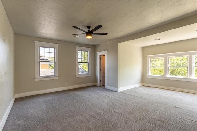 empty room featuring carpet flooring, ceiling fan, and a textured ceiling