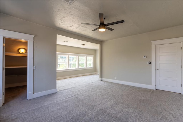 interior space featuring a textured ceiling, carpet floors, and ceiling fan