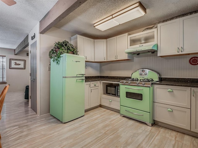 kitchen featuring white cabinets, white fridge, light hardwood / wood-style floors, and range