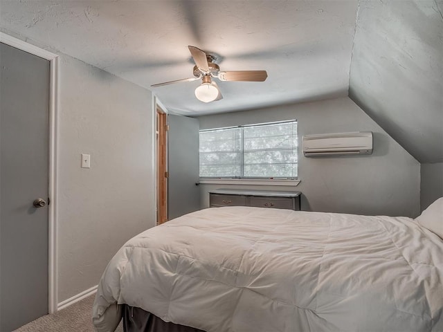 bedroom with vaulted ceiling, ceiling fan, carpet flooring, and a wall mounted air conditioner