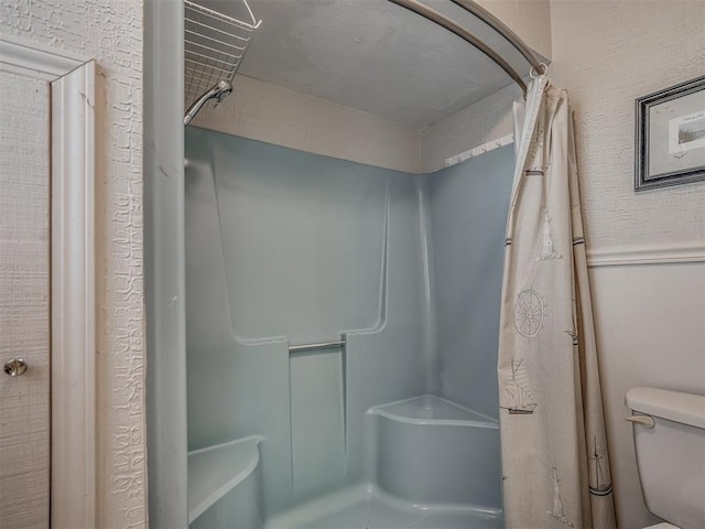 bathroom featuring a shower with curtain and toilet