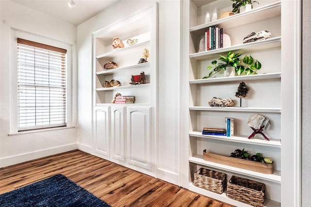 interior space with wood-type flooring and built in shelves