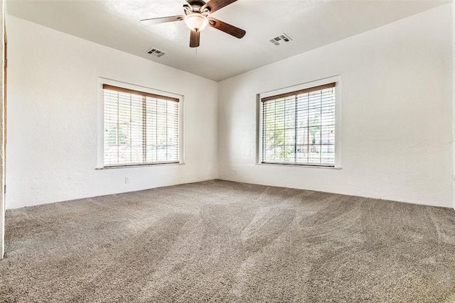 carpeted spare room featuring ceiling fan