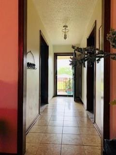 hallway with light tile patterned floors and a textured ceiling