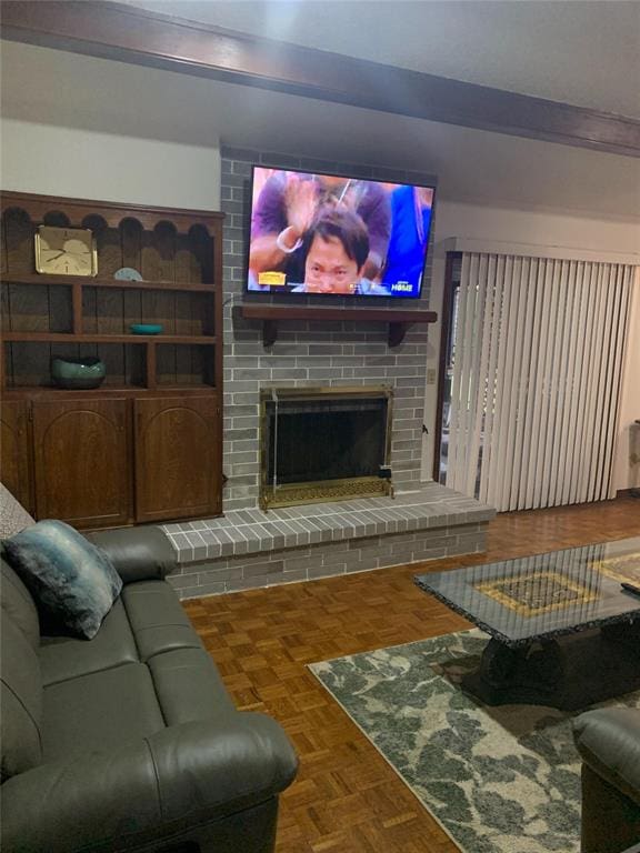 living room with a brick fireplace and parquet floors