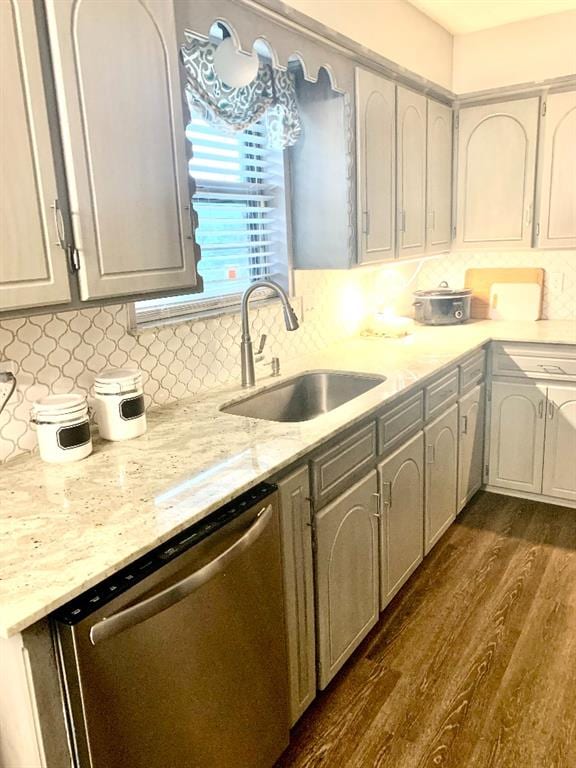 kitchen with dark hardwood / wood-style flooring, tasteful backsplash, stainless steel dishwasher, sink, and gray cabinets