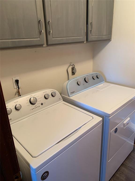 laundry room with washer and dryer, dark hardwood / wood-style floors, and cabinets