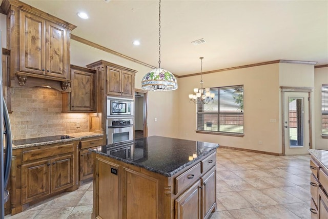 kitchen featuring a center island, ornamental molding, appliances with stainless steel finishes, and an inviting chandelier