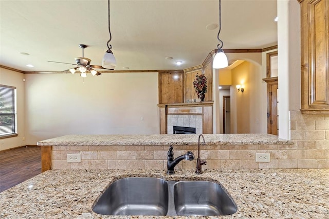 kitchen with sink, hanging light fixtures, crown molding, dark hardwood / wood-style floors, and ceiling fan