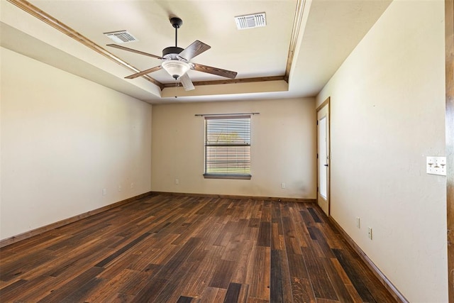 empty room featuring dark hardwood / wood-style floors, a raised ceiling, and ceiling fan