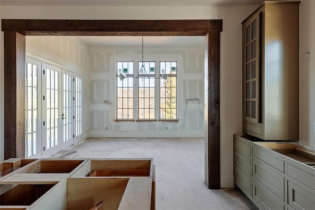 interior space featuring baseboards and a notable chandelier