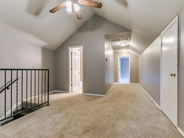 hallway with light colored carpet and vaulted ceiling