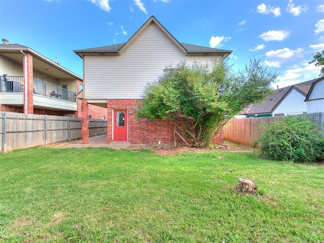 rear view of property featuring a lawn