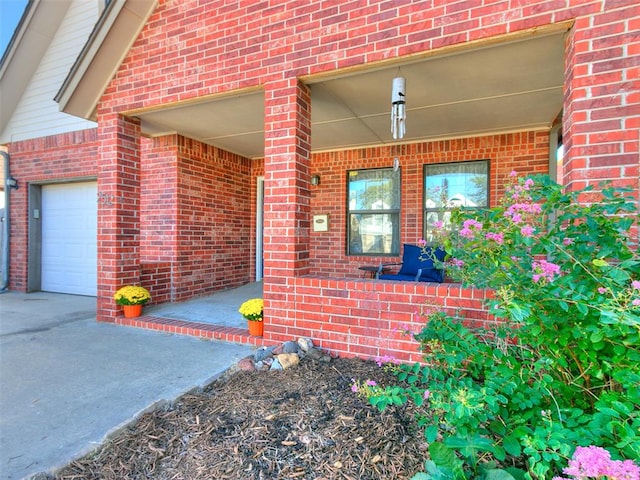 doorway to property with covered porch and a garage