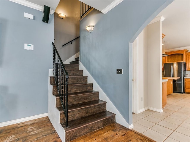 staircase featuring wood-type flooring and crown molding