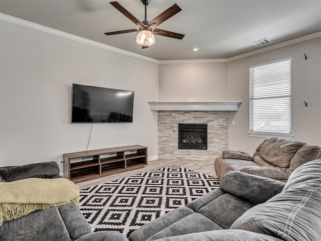 living room with hardwood / wood-style floors, ceiling fan, ornamental molding, and a tiled fireplace