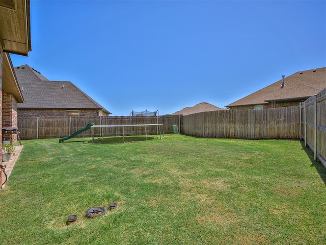 view of yard featuring a playground and a trampoline