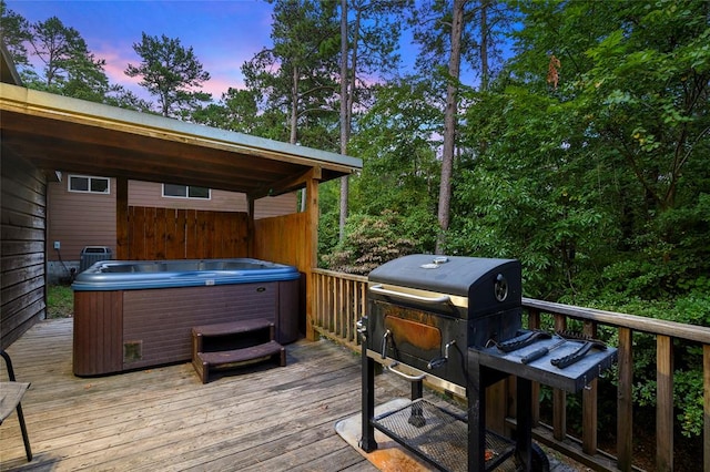 deck at dusk featuring a hot tub