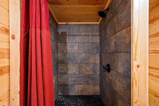 bathroom featuring a shower with curtain, wood ceiling, and wooden walls