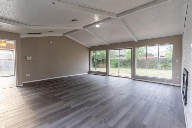 unfurnished living room with vaulted ceiling with beams, a fireplace, wood-type flooring, and a textured ceiling