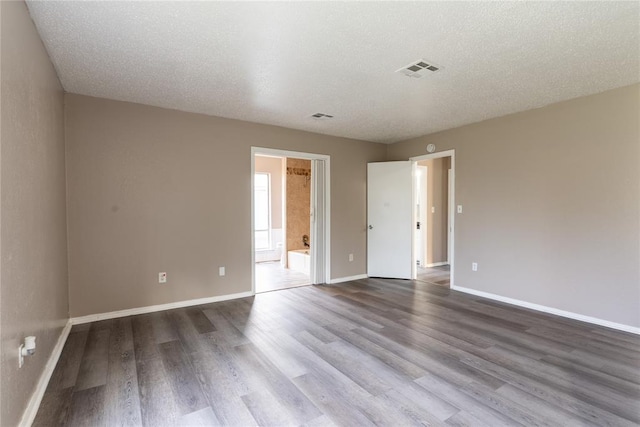 empty room featuring wood-type flooring and a textured ceiling