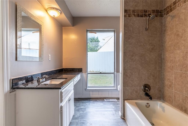 bathroom with vanity, tiled shower / bath combo, and plenty of natural light